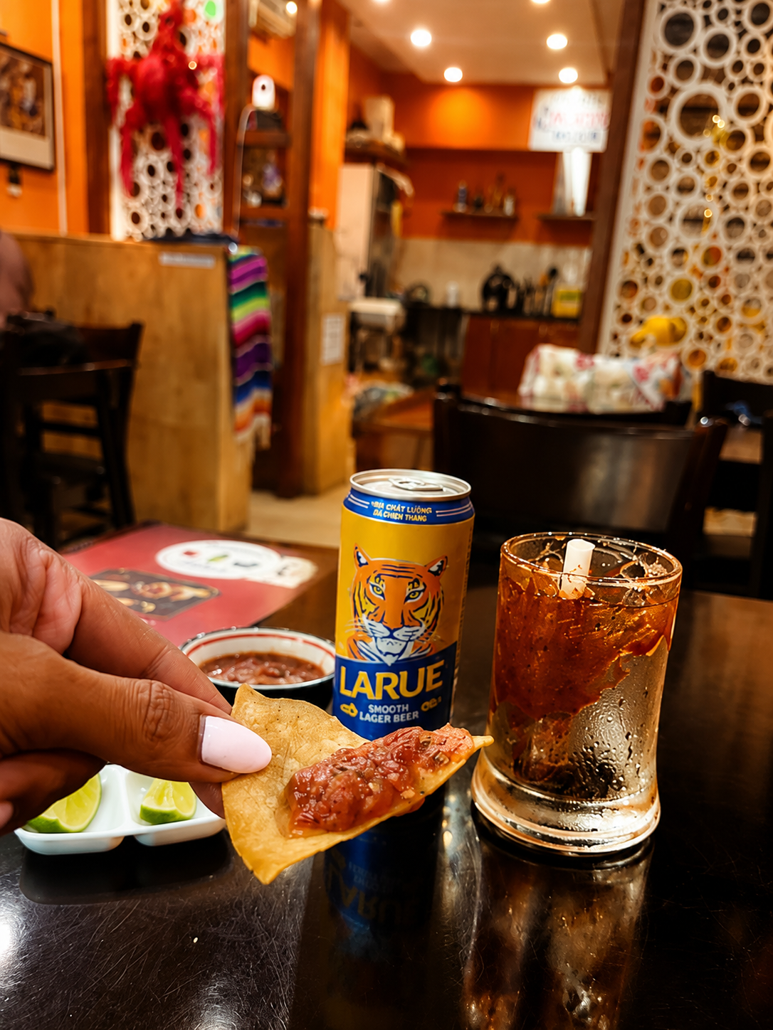 Salsa on a tortilla chip with a drink at Mexican Choice